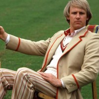 Peter Davison as the Fifth Doctor. seated and holding a cricket bat