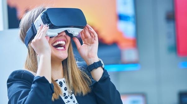 Woman with blonde hair laughing and wearing a virtual reality headset