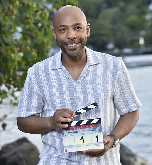 Don Gillet poses with a Death in Paradise clapperboard