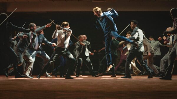 Men in suits charge at one another as thought they're on a medieval battlefield, wielding swords
