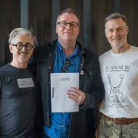 Russel T Davies holds a script for Tip Toe and stands in the middle with Alan Cummings on his left and David Morrissey on his right