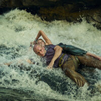 Charlize Theron and Taron Egerton fight in white water rapids in Apex