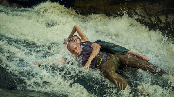 Charlize Theron and Taron Egerton fight in white water rapids in Apex