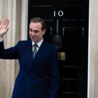 A fictional prime minister stands outside Number 10