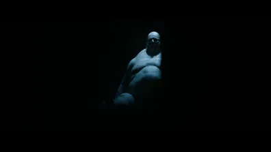 A character sits ominously in the shadows in the Resident Evil film trailer.