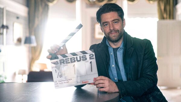 Main actor of Rebus holding a clapper board of the second season