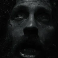 Terrified bedraggled man's face in black and white from the Werwulf trailer