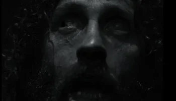 Terrified bedraggled man's face in black and white from the Werwulf trailer