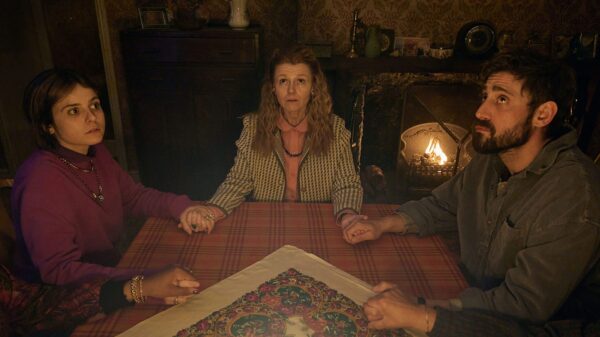 A still from The Witch Farm with characters conducting a seance